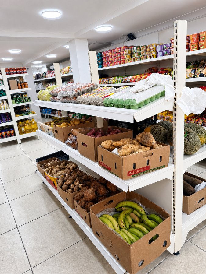 Shelf of plantain, sweet potato, cassava, coconut, eggs and melons