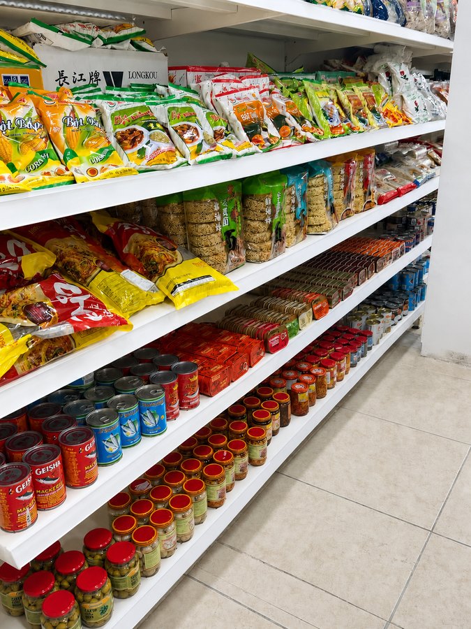 Shelves of Geisha mackerel tins, sardines, olives and dried noodles